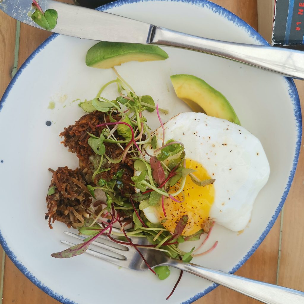 Vegetarian brunch wth egg and avocado and sweet potato hash browns at The Real Coconut restaurant in Tulum Mexico