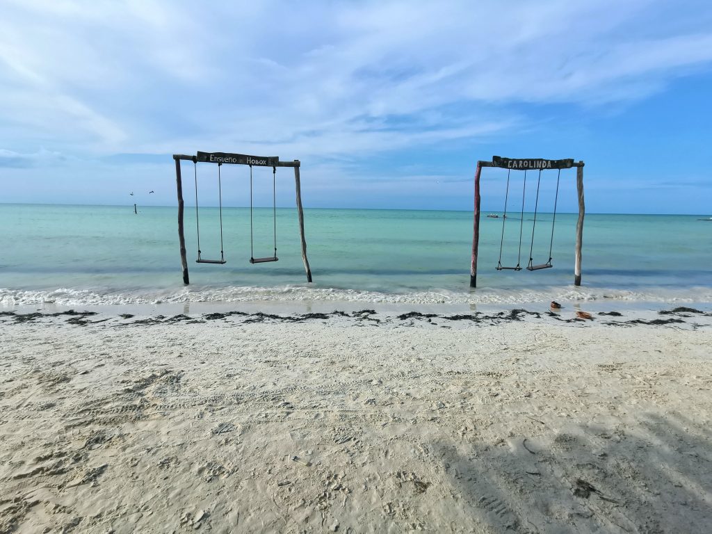 Beach swings Instagram spot with white sad and blue waters on Isla Holbox Mexico