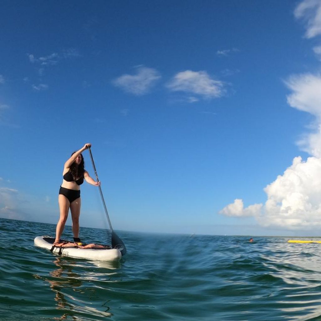 Solo female traveler paddleboarding off the coast of Isla Holbox, Mexico