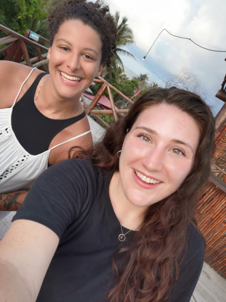 Two solo female travelers meet a rooftop bar in Tulum Mexico