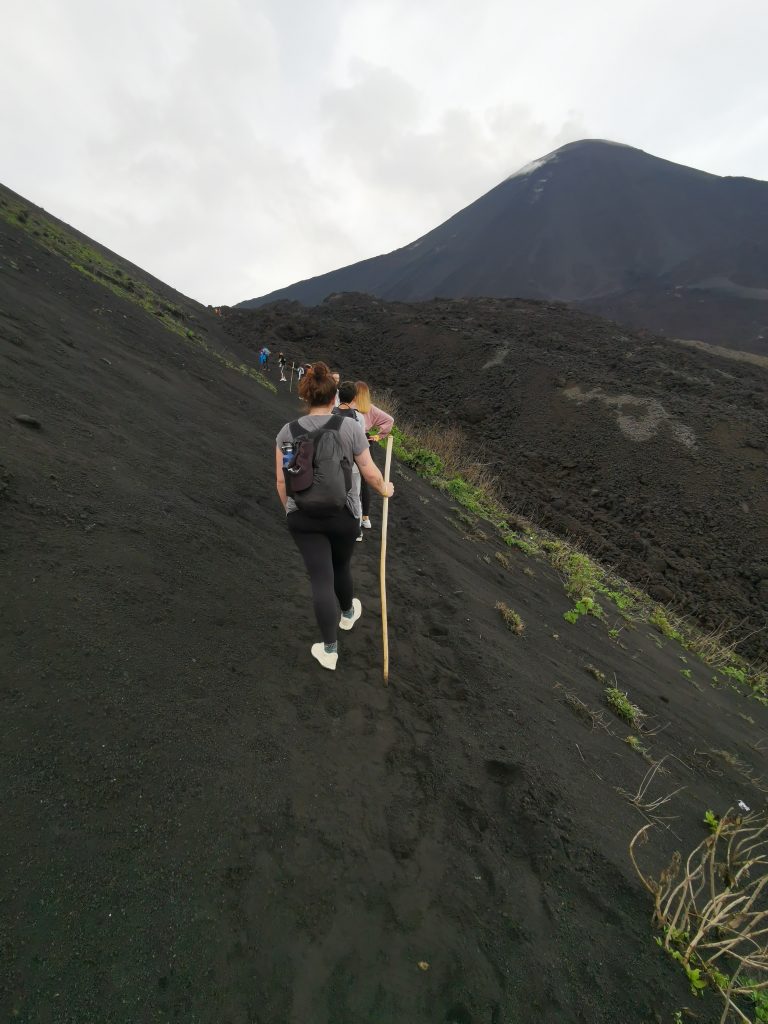 Solo female traveler with friends hiking a volcano in Guatemala