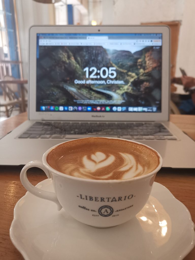 A coffee and a laptop at a digital nomad's table in Libertario Cafe in Cartagena Colombia