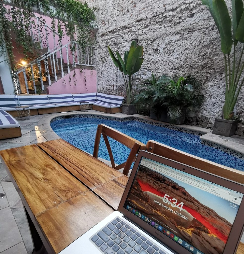 Digital nomad works from a colorful hostel terrace with a swimming pool in Cartagena Colombia